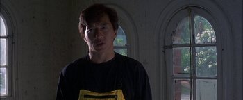 Movie still from “First Strike” (1996), directed by Stanley Tong – A man wearing an apron standing next to a window; Close Up shot, Low angle