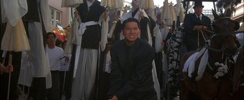 Movie still from “First Strike” (1996), directed by Stanley Tong – A group of people in black robes holding white umbrellas; Medium shot, Low angle