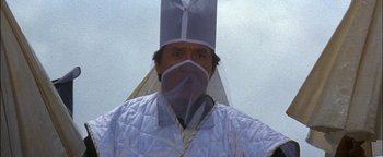 Movie still from “First Strike” (1996), directed by Stanley Tong – A man wearing a white jacket and a white hat; Close Up shot, Low angle