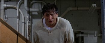 Movie still from “First Strike” (1996), directed by Stanley Tong – A man in a white shirt and a white t - shirt; Close Up shot, Low angle