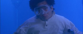 Movie still from “First Strike” (1996), directed by Stanley Tong – A man wearing goggles and a white shirt; Medium shot, Low angle