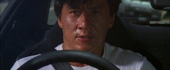 Movie still from “First Strike” (1996), directed by Stanley Tong – A person driving a car; Close Up shot, High angle