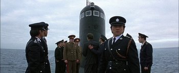 Movie still from “First Strike” (1996), directed by Stanley Tong – A group of men standing in front of a large submarine; Medium shot, Low angle