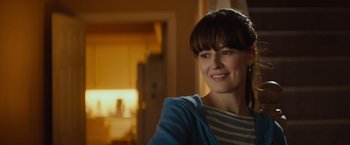 Movie still from “Poltergeist” (2015), directed by Gil Kenan – A woman smiling for the camera while wearing a blue jacket; Close Up shot, Over the shoulder angle