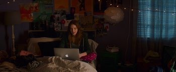 Movie still from “Poltergeist” (2015), directed by Gil Kenan – A woman sitting in a chair using a laptop computer; Wide shot, High angle