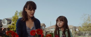Movie still from “Poltergeist” (2015), directed by Gil Kenan – A woman and a girl standing next to flowers; Close Up shot, Over the shoulder angle