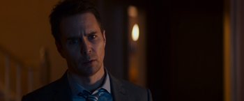 Movie still from “Poltergeist” (2015), directed by Gil Kenan – A person wearing a suit and tie; Close Up shot, Over the shoulder angle