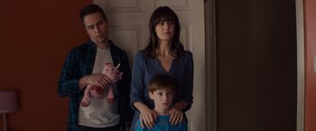 Movie still from “Poltergeist” (2015), directed by Gil Kenan – A man and a woman standing next to a child; Medium shot, Low angle