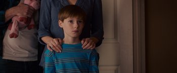 Movie still from “Poltergeist” (2015), directed by Gil Kenan – A young boy is being held by a woman; Close Up shot, Over the shoulder angle