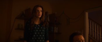 Movie still from “Poltergeist” (2015), directed by Gil Kenan – A woman standing in a dark room with a book shelf in the background; Medium shot, Low angle