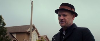 Movie still from “Poltergeist” (2015), directed by Gil Kenan – A person wearing a hat near a pole; Close Up shot, Low angle