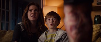 Movie still from “Poltergeist” (2015), directed by Gil Kenan – A woman and a boy are watching television; Close Up shot, Low angle
