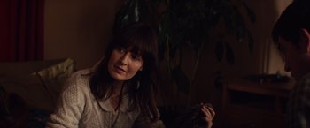 Movie still from “Poltergeist” (2015), directed by Gil Kenan – A woman sitting in front of a potted plant in a room; Close Up shot, Over the shoulder angle