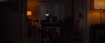 Movie still from “Poltergeist” (2015), directed by Gil Kenan – A dimly - lit dining room table with a lamp on top of it; Extreme Wide shot, High angle