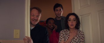 Movie still from “Poltergeist” (2015), directed by Gil Kenan – A group of people sitting in front of a wall; Medium shot, Over the shoulder angle