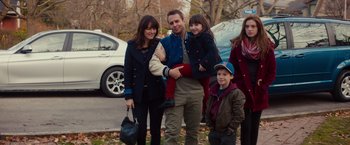 Movie still from “Poltergeist” (2015), directed by Gil Kenan – A family posing for a picture in a park; Medium shot, Over the shoulder angle