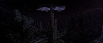 Movie still from “Poltergeist II: The Other Side” (1986), directed by Brian Gibson – An image of a man standing on top of a tall tower in the middle of the night sky; Extreme Wide shot, Low angle