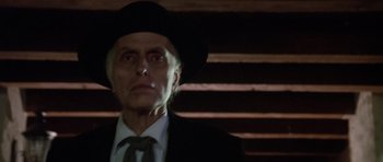 Movie still from “Poltergeist II: The Other Side” (1986), directed by Brian Gibson – An older man in a suit and hat looking into the distance; Close Up shot, Low angle