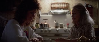 Movie still from “Poltergeist II: The Other Side” (1986), directed by Brian Gibson – Two women in a kitchen preparing a meal together; Medium shot, Over the shoulder angle