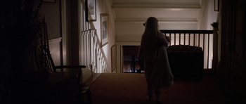 Movie still from “Poltergeist II: The Other Side” (1986), directed by Brian Gibson – A woman walking down the hall way of a house; Wide shot, High angle