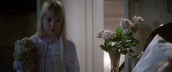 Movie still from “Poltergeist II: The Other Side” (1986), directed by Brian Gibson – A little girl standing next to a vase of flowers; Close Up shot, High angle
