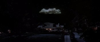 Movie still from “Poltergeist II: The Other Side” (1986), directed by Brian Gibson – A night sky with a cloud in the sky above a house; Extreme Wide shot, Low angle
