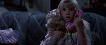 Movie still from “Poltergeist II: The Other Side” (1986), directed by Brian Gibson – A little girl holding a phone in her hand; Close Up shot, High angle