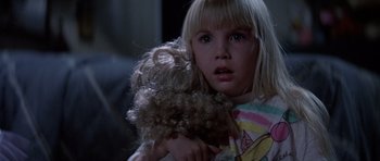 Movie still from “Poltergeist II: The Other Side” (1986), directed by Brian Gibson – A little girl holding a teddy bear in her arms; Close Up shot, Over the shoulder angle