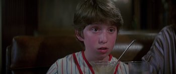 Movie still from “Poltergeist II: The Other Side” (1986), directed by Brian Gibson – A young boy is holding a glass of milk; Close Up shot, Over the shoulder angle