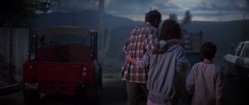 Movie still from “Poltergeist II: The Other Side” (1986), directed by Brian Gibson – A man and a woman hugging in front of a truck; Wide shot, Over the shoulder angle