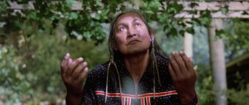 Movie still from “Poltergeist II: The Other Side” (1986), directed by Brian Gibson – An older native american man with long hair and earrings; Close Up shot, Low angle
