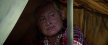 Movie still from “Poltergeist II: The Other Side” (1986), directed by Brian Gibson – An older man with long hair and a plaid shirt; Close Up shot, Over the shoulder angle