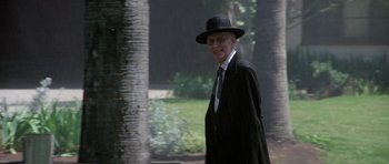 Movie still from “Poltergeist II: The Other Side” (1986), directed by Brian Gibson – An older man in a black suit and a black hat; Medium shot, Low angle