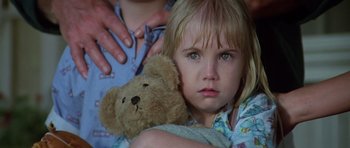 Movie still from “Poltergeist II: The Other Side” (1986), directed by Brian Gibson – A little girl holding a teddy bear in her arms; Close Up shot, Low angle