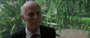 Movie still from “Poltergeist II: The Other Side” (1986), directed by Brian Gibson – An older man in a suit and tie looking angry; Close Up shot, Low angle