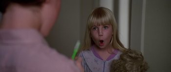 Movie still from “Poltergeist II: The Other Side” (1986), directed by Brian Gibson – A young girl is looking into a mirror at a toothbrush; Close Up shot, Over the shoulder angle