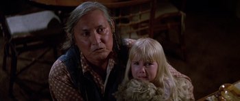 Movie still from “Poltergeist II: The Other Side” (1986), directed by Brian Gibson – An older man and a young girl are looking at the camera; Close Up shot, Over the shoulder angle