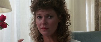 Movie still from “Poltergeist II: The Other Side” (1986), directed by Brian Gibson – A person with curly brown hair; Close Up shot, Over the shoulder angle