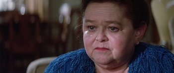 Movie still from “Poltergeist II: The Other Side” (1986), directed by Brian Gibson – An older woman is crying while sitting on a couch; Close Up shot, High angle