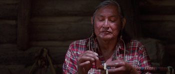 Movie still from “Poltergeist II: The Other Side” (1986), directed by Brian Gibson – An older woman is holding a wooden object; Close Up shot, Low angle