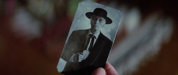 Movie still from “Poltergeist II: The Other Side” (1986), directed by Brian Gibson – An old photo of a man in a suit and hat; Extreme Close Up shot, Low angle