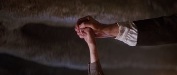 Movie still from “Poltergeist II: The Other Side” (1986), directed by Brian Gibson – Two people holding hands while standing in a room; Extreme Close Up shot, Low angle