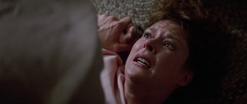 Movie still from “Poltergeist II: The Other Side” (1986), directed by Brian Gibson – An older woman is laying on the floor with her eyes closed; Close Up shot, Overhead angle