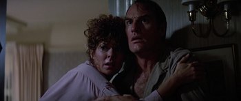 Movie still from “Poltergeist II: The Other Side” (1986), directed by Brian Gibson – A man and a woman sitting next to each other in a room; Close Up shot, Low angle