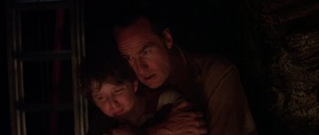 Movie still from “Poltergeist II: The Other Side” (1986), directed by Brian Gibson – A man and a boy in a dark room; Close Up shot, High angle