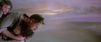 Movie still from “Poltergeist II: The Other Side” (1986), directed by Brian Gibson – A man with long hair and a beard looking down at the sky; Medium shot, Low angle