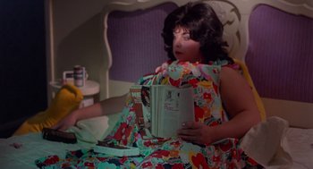 A woman sitting in a bed reading a book