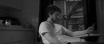 Movie still from “Polytechnique” (2009), directed by Denis Villeneuve – Black and white photograph of a man sitting in a chair; Medium shot, High angle