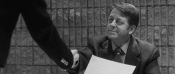 Movie still from “Polytechnique” (2009), directed by Denis Villeneuve – A black and white photo of a man shaking hands with another man; Close Up shot, Over the shoulder angle