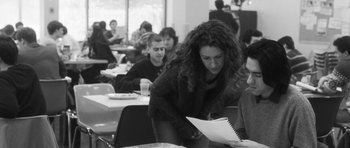 Movie still from “Polytechnique” (2009), directed by Denis Villeneuve – A group of people sitting at tables in a room; Medium shot, Over the shoulder angle